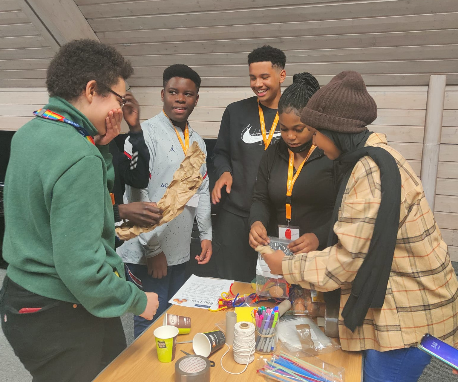 a group of young people having fun by a table of craft materials