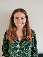 A photo of sally in a green blouse on a pale background