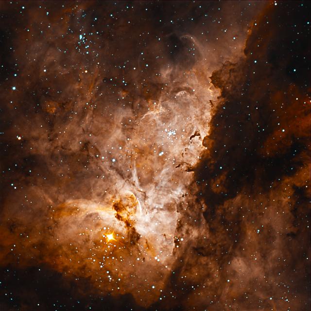 An image of a reddish nebula cloud surrounded by stars
