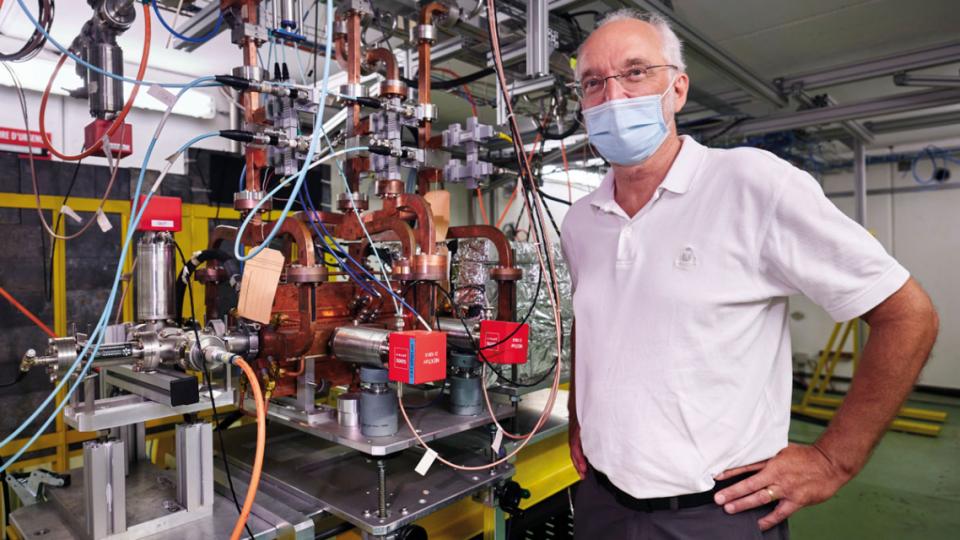 Speaker Walter Wuensch standing in front of a prototype CLIC cavity