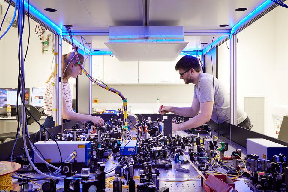 Two research scientists over a laser table