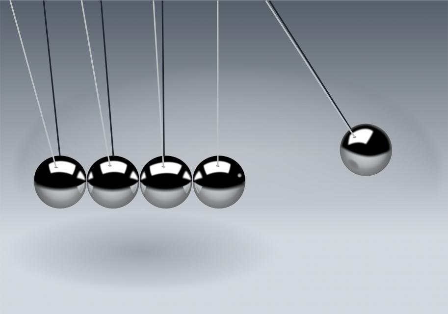 a newton's cradle with five balls, the right hand one is raised up and about to fall