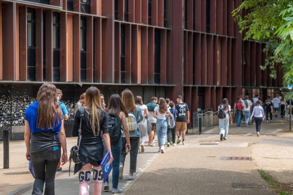 Prospective students walking past the Beecroft Building at open day