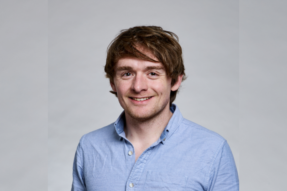 James Matthews in blue collared shirt smiling 