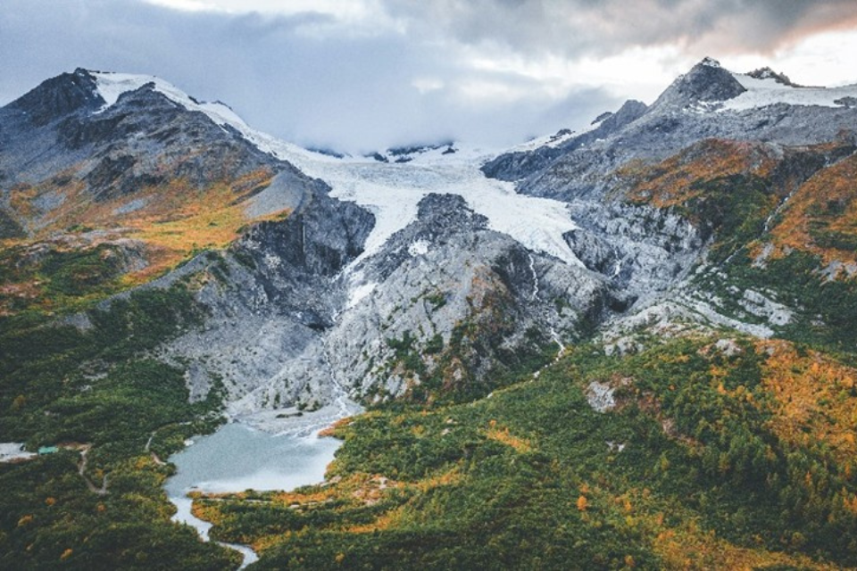 Aerial view of a rugged mountain range featuring a prominent glacier, showcasing the natural beauty of the landscape.