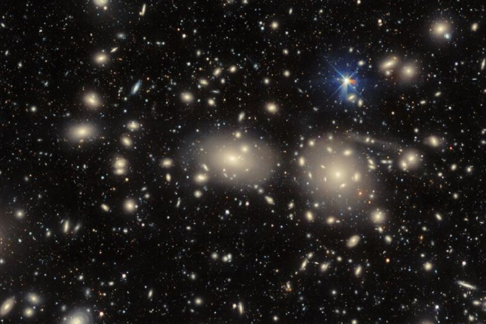 A cluster of galaxies illuminated against the dark sky, showcasing their vibrant colours and intricate formations.