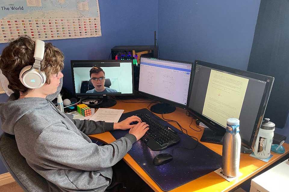 Male teenage student in front of computer screens