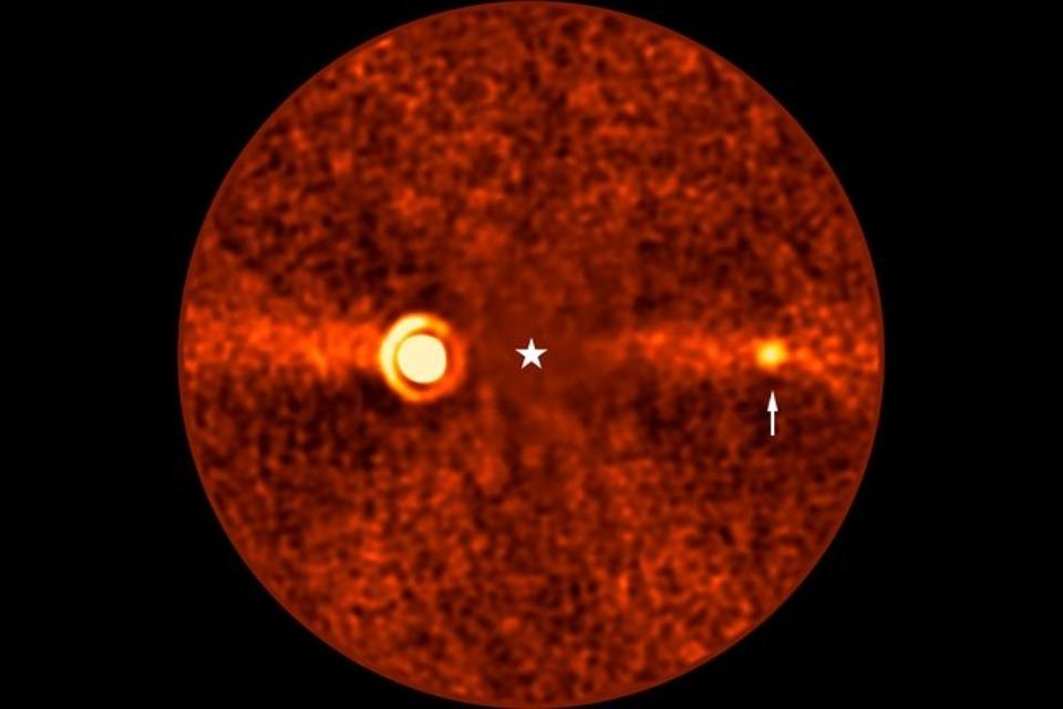 This image, taken with ESO’s Very Large Telescope (VLT) shows Beta Pictoris d, a new planet found orbiting the star Beta Pictoris. The star is at the centre of the frame, and was subtracted when processing the data, revealing the environment around it. The new planet, indicated with an arrow, is the third one found around this star. The other two are Beta Pictoris b –– the bright source to the left, and Beta Pictoris c, orbiting much closer to the star and not seen here.