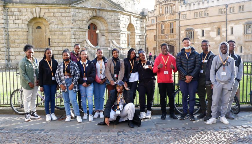 a photo of a group of young Black students standing in front of the Radcliffe Camera in Oxford