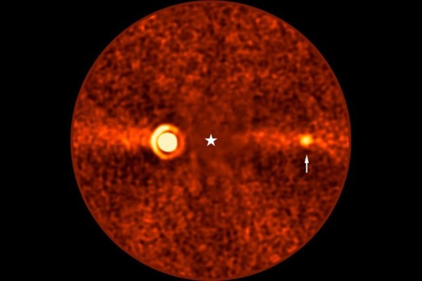 This image, taken with ESO’s Very Large Telescope (VLT) shows Beta Pictoris d, a new planet found orbiting the star Beta Pictoris. The star is at the centre of the frame, and was subtracted when processing the data, revealing the environment around it. The new planet, indicated with an arrow, is the third one found around this star. The other two are Beta Pictoris b –– the bright source to the left, and Beta Pictoris c, orbiting much closer to the star and not seen here.