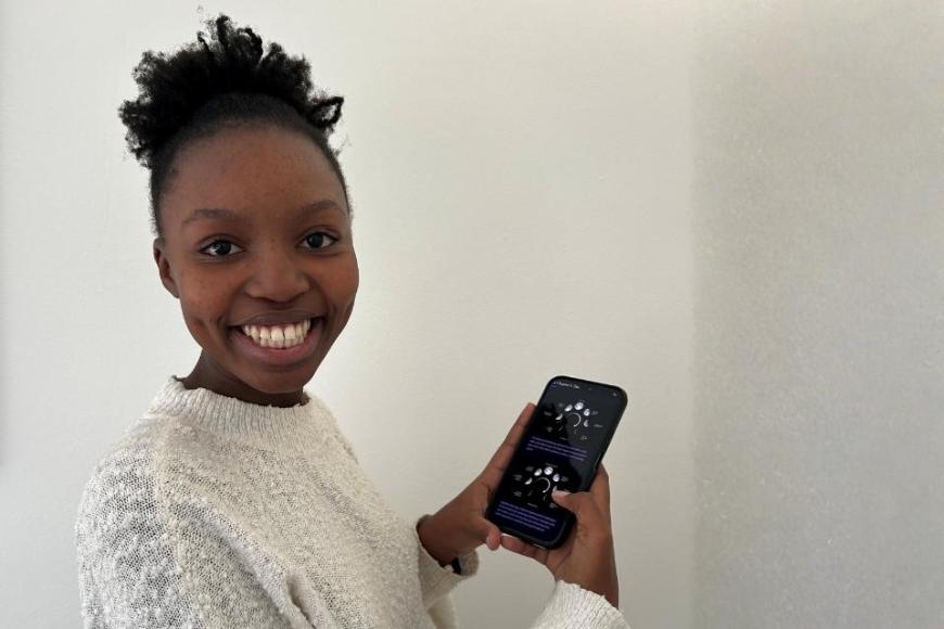 Female from South Africa holding a phone showing the STEP into the Cosmos webapp