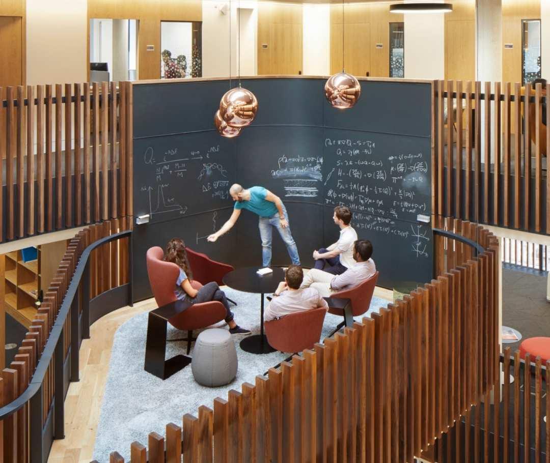 Researchers discussing around a black board