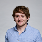 James Matthews in blue collared shirt smiling 