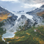 Aerial view of a rugged mountain range featuring a prominent glacier, showcasing the natural beauty of the landscape.