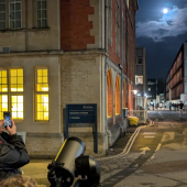 Attendees with phones and telescopes observing moon at Department of Physics