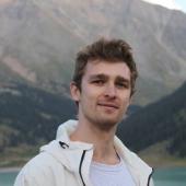 Dr Richard Nies in a white jacket with a mountain background. 