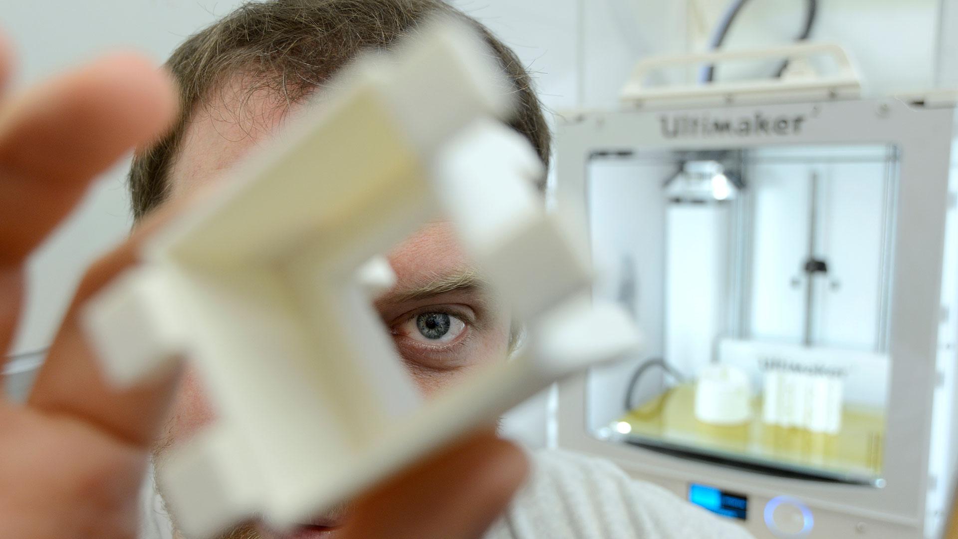 Man looking through hole in custom-made part