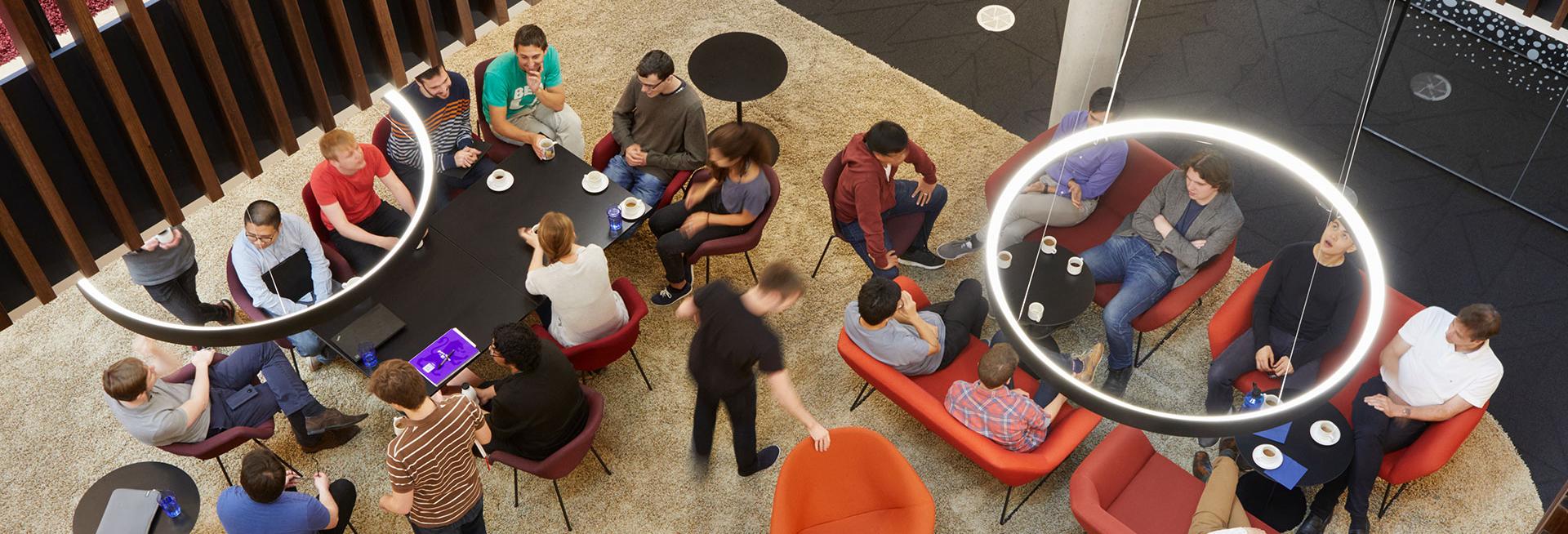 Aerial shot of people sitting on chairs around tables in the Beecroft building, Department of Physics