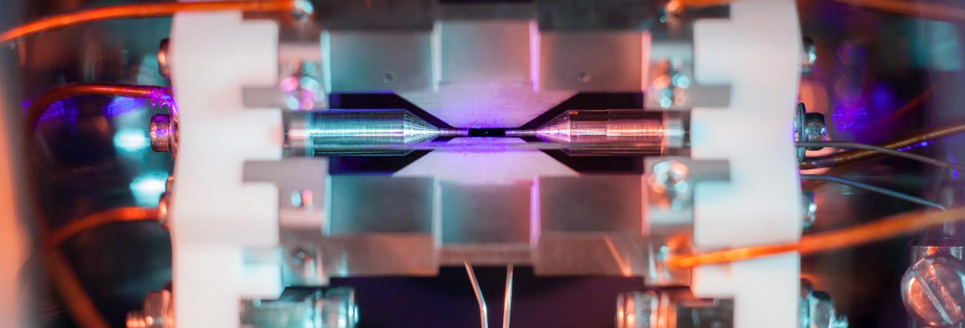 A photograph of a single positively-charged strontium atom, held near motionless by electric fields emanating from the metal electrodes surrounding it 
