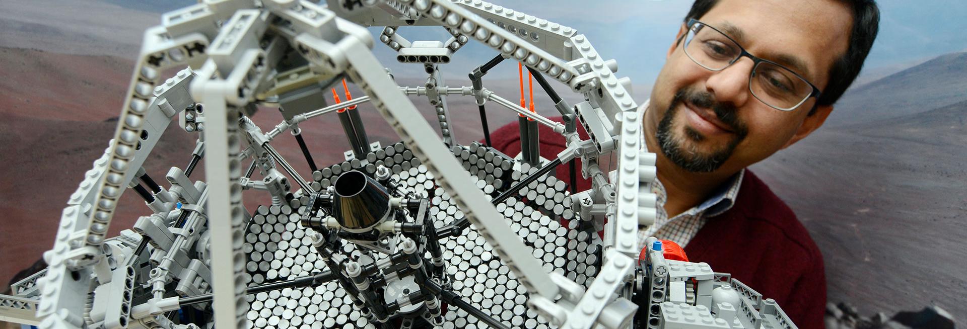 Professor Niranjan Thatte looking at a Lego model of the Extremely Large Telescope for which he leads the efforts to build the HARMONI instrument