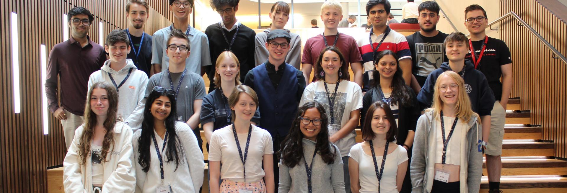 a group of summer school students on some wooden steps in the Beecroft Building