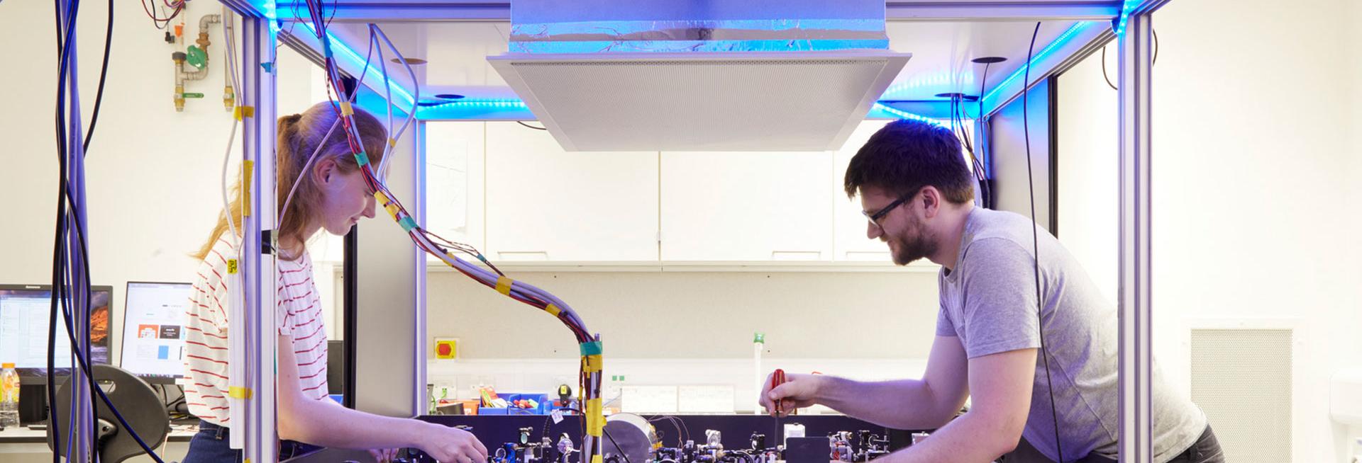 Two research scientists over a laser table