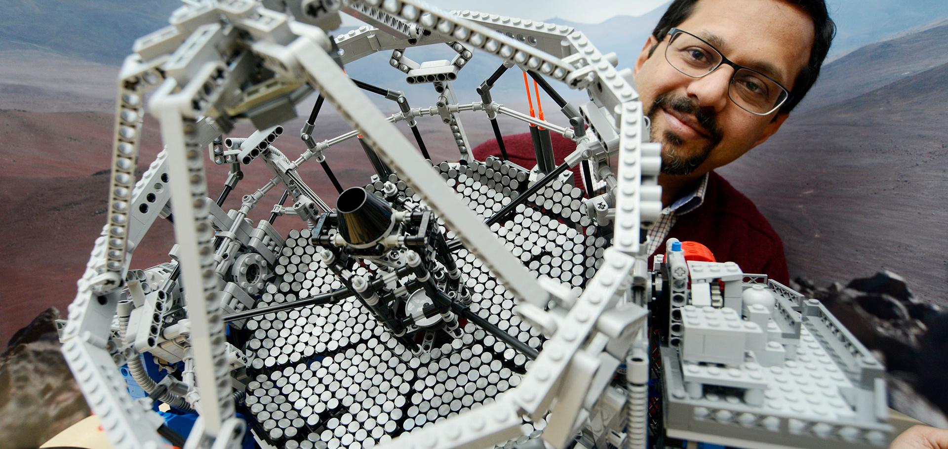 Man with Lego model of a telescope