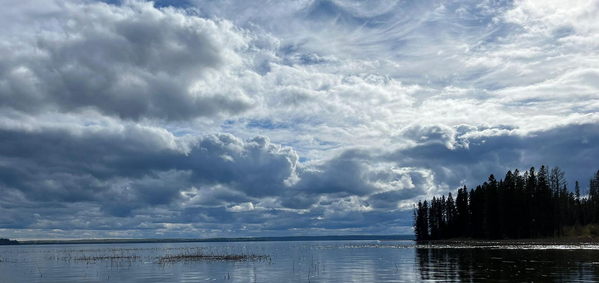 A splendidly cloudy sky above a calm lake in Northern Canada.