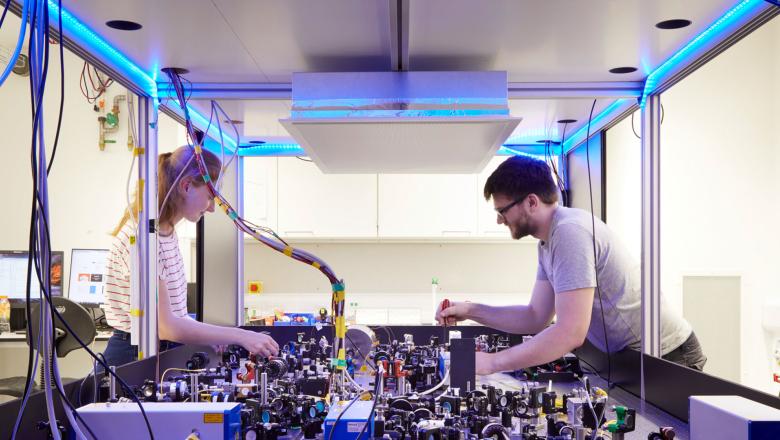 Two research scientists over a laser table
