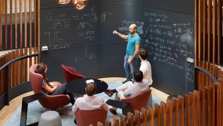 A group of people working on a blackboard in the Beecroft Building