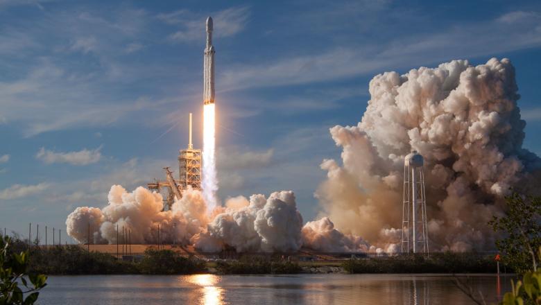 a photo of a space X rocket launch with big clouds of steam and a fiery rocket