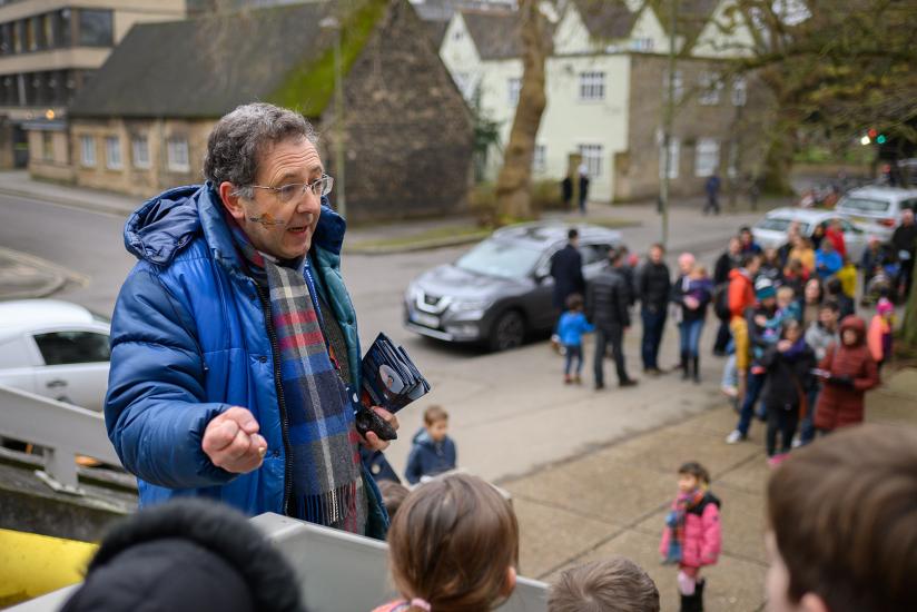 Man talking outside with people in background and foreground