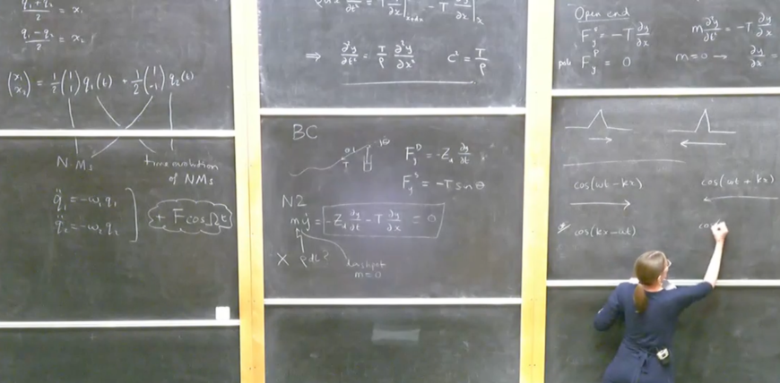 Hannah Christensen writing maths equations on a blackboard