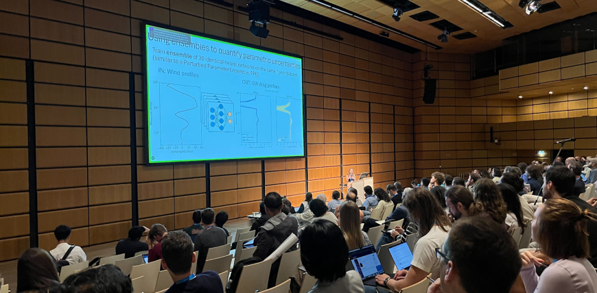 Scientific presentation being given to crowded conference room